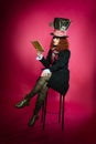 Portrait of young woman in the similitude of the Hatter reading Royalty Free Stock Photo