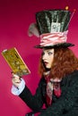 Portrait of young woman in the similitude of the Hatter reading Royalty Free Stock Photo