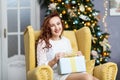 Portrait of young woman with christmas present boxes in front of christmas tree Royalty Free Stock Photo