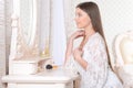 Portrait of young woman sitting at dressing table Royalty Free Stock Photo