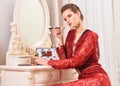 Portrait of young woman sitting at dressing table Royalty Free Stock Photo