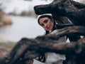 Portrait of young woman sitting in forest near trunk tree Royalty Free Stock Photo