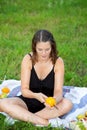 Young woman sitting in park and cutting an orange Royalty Free Stock Photo