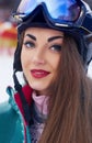 Portrait of young woman at the ski resort on the background of mountains and blue sky.A mountain range reflected in the ski mask. Royalty Free Stock Photo