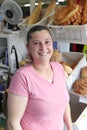 Portrait of a young woman smiling, serving customers in a bread office