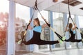 Portrait of young woman in sportswear doing push-ups while legs hanging on trx in the fitness gym Royalty Free Stock Photo