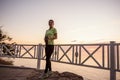 Portrait of young woman in sportswear, stopped for break between workouts. Sportswoman looks at dawn Royalty Free Stock Photo