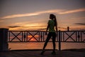 Portrait of young woman in sportswear, stopped for break between workouts. Sportswoman looks at dawn Royalty Free Stock Photo