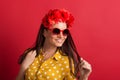 A young woman in studio with sunglasses and red flower headband. Royalty Free Stock Photo