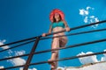 Portrait of a young woman in a swimsuit and beach hat. Glamorous brunette woman smiling and sunbathing Royalty Free Stock Photo