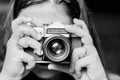 Portrait of young woman taking photos with vintage retro camera. Black and white Royalty Free Stock Photo