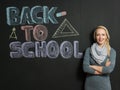 Portrait of a young woman, teacher in front of a blackboard