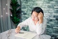 Portrait of young woman thinking while serious working at home with laptop on desk