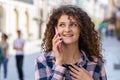 Happy woman girl having remote conversation talking on smartphone, good news gossip in city street Royalty Free Stock Photo