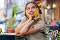 Happy woman having remote conversation talking on smartphone, good news gossip in city cafeteria Royalty Free Stock Photo