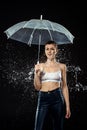 portrait of young woman with umbrella swilled with water