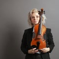 Portrait of an young woman violinist in a black male suit with a violin Royalty Free Stock Photo