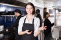 Portrait of young woman waiter who is satisfied of work on kitchen Royalty Free Stock Photo