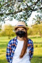 Portrait of young woman wearing black face mask. Dust protection against virus. Coronavirus pandemic time. Girl in American