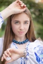 Portrait of young woman wearing blue national traditional embroidered shirt. pretty girl outdoor dressed in patriotic Royalty Free Stock Photo