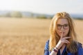 Young woman is gesturing Shhh in corn field