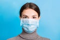 Portrait of young woman wearing medical mask at blue background. Protect your health. concept