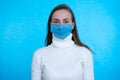 Portrait of young woman wearing medical mask at blue background. Protect your health. Coronavirus concept Royalty Free Stock Photo
