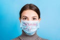 Portrait of young woman wearing medical mask with nCoV word at blue background. Protect your health. Coronavirus Royalty Free Stock Photo