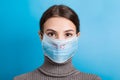 Portrait of young woman wearing medical mask with MERS word at blue background. Protect your health. concept Royalty Free Stock Photo