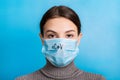 Portrait of young woman wearing medical mask with nCoV word at blue background. Protect your health. concept Royalty Free Stock Photo