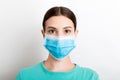 Portrait of young woman wearing medical mask at white background. Protect your health. Coronavirus concept Royalty Free Stock Photo