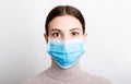 Portrait of young woman wearing medical mask at white background. Protect your health. Coronavirus concept Royalty Free Stock Photo