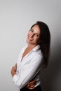 Portrait of young woman wearing white classic shirt posing isolated over grey wall background. Space for text. Royalty Free Stock Photo