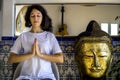 Portrait of young woman in white tshirt and with short hair sitting in meditation pose. Royalty Free Stock Photo