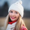 Portrait of young woman in white winter hat and red jumper, closeup to her smiling face Royalty Free Stock Photo