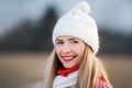 Portrait of young woman in white winter hat and red jumper, closeup to her smiling face Royalty Free Stock Photo