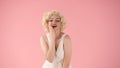 Portrait young woman in wig, white dress and with red lipstick on lips in studio on pink background. Woman looking like Royalty Free Stock Photo