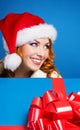 Portrait of a young woman in a winter hat holding a present Royalty Free Stock Photo