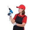 Portrait of young woman worker smiling in red uniform with apron, glove hand holding electric drill isolated on white backround Royalty Free Stock Photo
