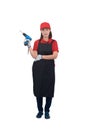 Portrait of young woman worker smiling in red uniform with apron, glove hand holding electric drill isolated on white backround Royalty Free Stock Photo