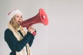 Portrait of young women shouting using megaphone over background Girl in white shirt, studio shot. Royalty Free Stock Photo