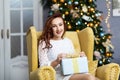 Portrait of young woman with christmas present boxes in front of christmas tree Royalty Free Stock Photo