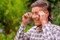 Portrait of young worker wearing transparent safety glasses, long sleeve shirt and ear plugs to protect from noise, in a