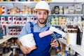 Portrait of young workman holding rollers