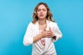 Portrait of young worried businesswoman suffering pain in chest, having heart attack. isolated, blue background Royalty Free Stock Photo
