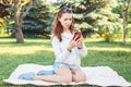 Caucasian teenage girl talking over cell mobile phone outside in park Royalty Free Stock Photo