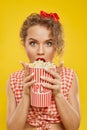 Portrait of ypung shocked girl holding bucket of popcorn