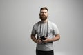 Portraite of bearded professional photographer with dslr camera isolated on gray background.