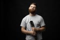 Portraite of handsome brunette bearded man musician, guitarist standing and holding a acoustic guitar in a hand and