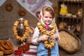 Portraite of little girl in a traditional Russian headscarf and sundress with bunch of bagels. Royalty Free Stock Photo